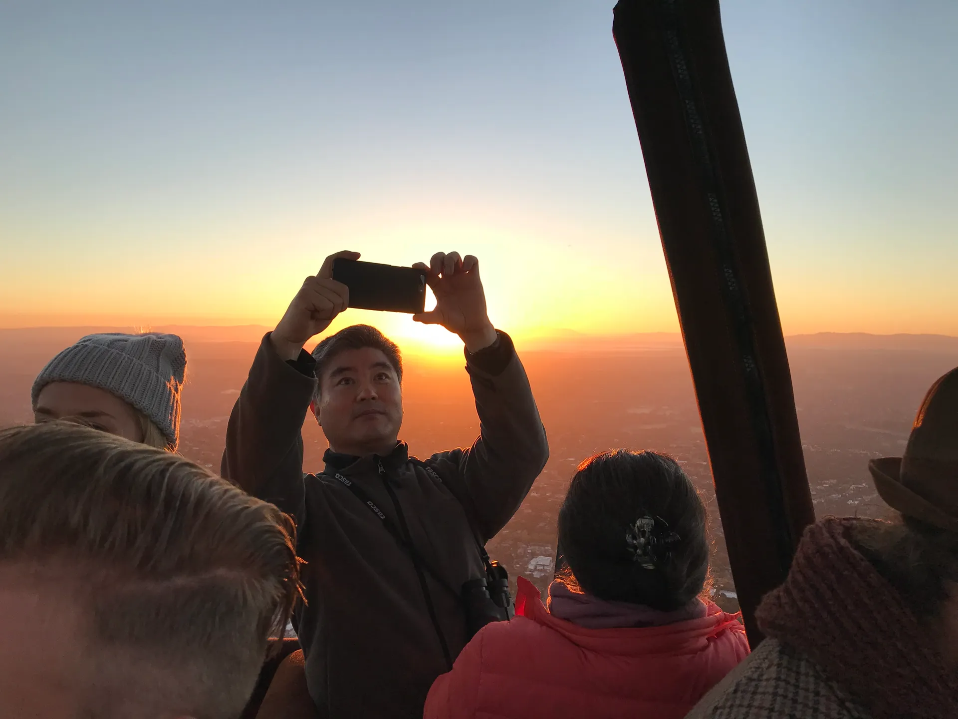A hot-air balloon rising at sunrise