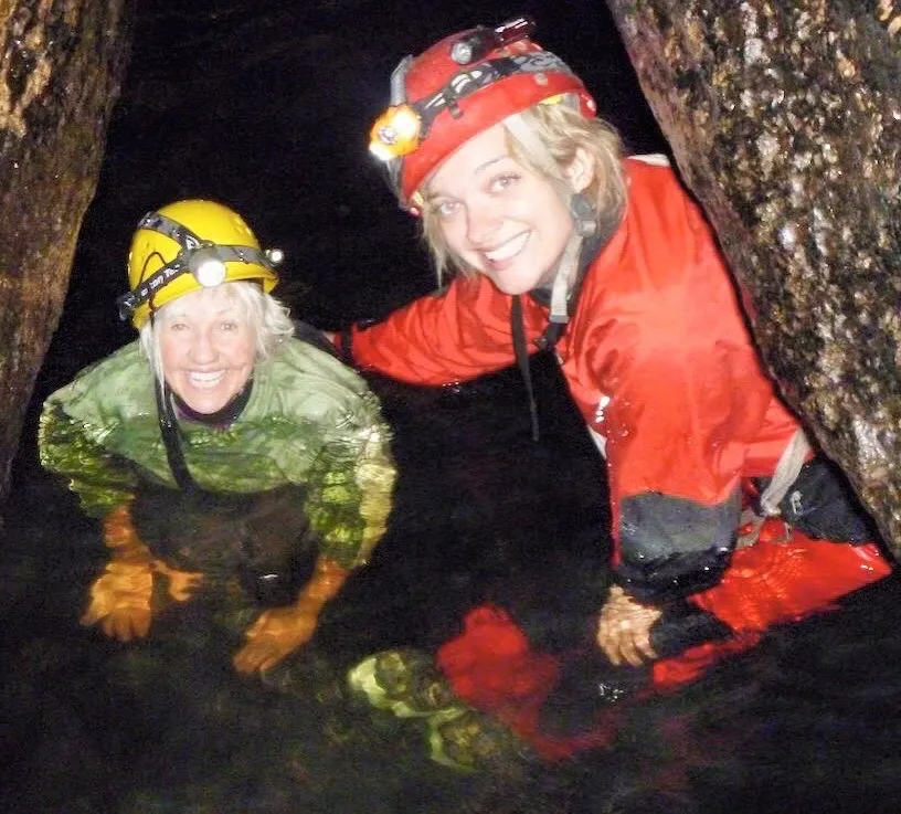 A headlamp-lit limestone cave and underground river