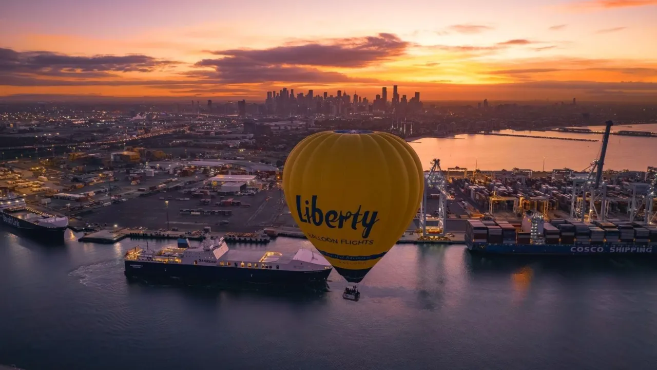 A hot air balloon rising over Melbourne at sunrise