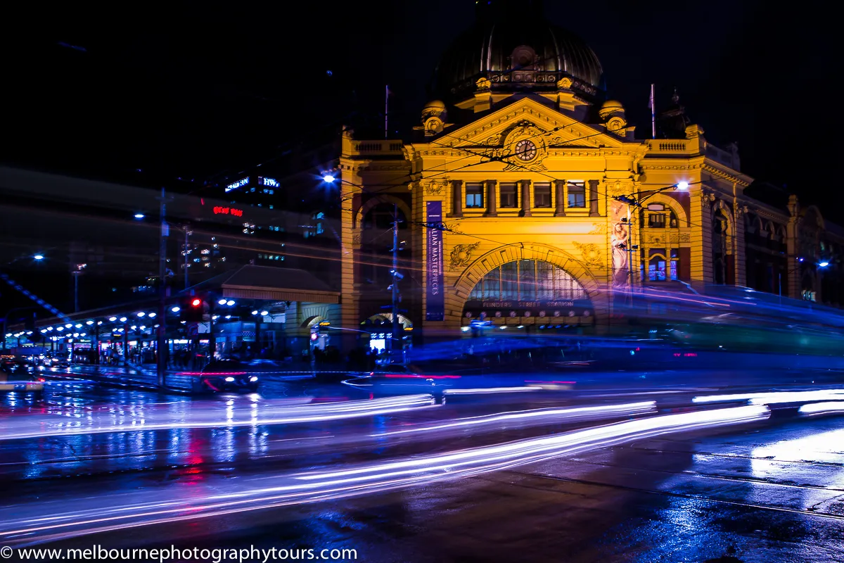A camera and tripod framing the Melbourne skyline at blue hour